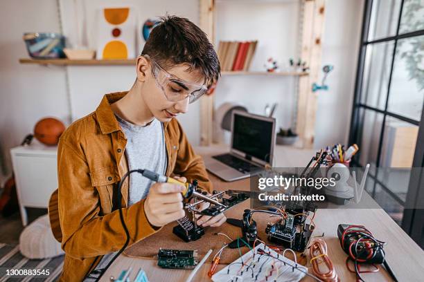 elementos de soldadura de niño adolescente en placa de circuito - model kit fotografías e imágenes de stock