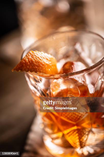 old fashioned whiskey drink on ice with orange zest garnish. - rum tasting stock pictures, royalty-free photos & images