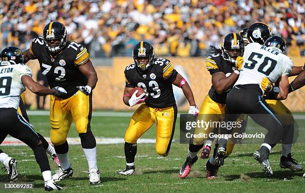 Running back Isaac Redman of the Pittsburgh Steelers runs with the football behind the blocking of offensive lineman Jonathan Scott and tight end...