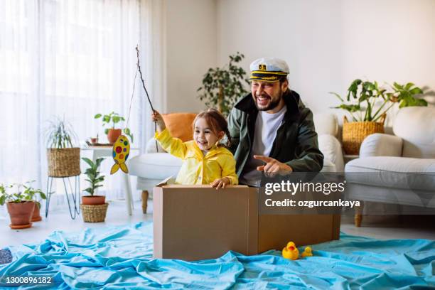 little girl with father playing fishing at home - adult imagination stock pictures, royalty-free photos & images