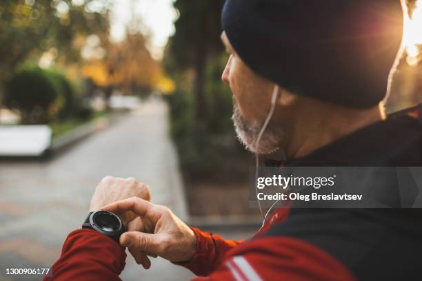 athletic runner start training on fitness tracker or smart watch and looking forward - fitnesstracker stock pictures, royalty-free photos & images