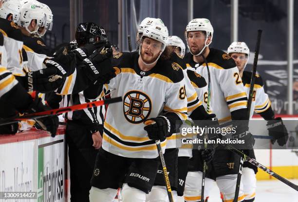 David Pastrnak of the Boston Bruins celebrates his goal in the third period against the Philadelphia Flyers with teammates on the bench at the Wells...