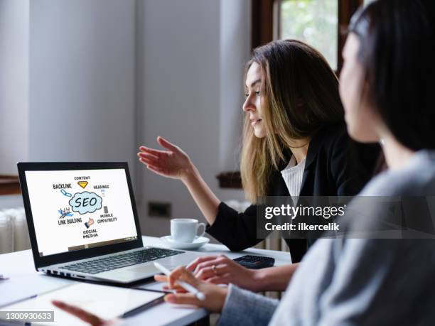 suchmaschinenoptimierung (seo) konzept auf dem computerbildschirm mit zwei geschäftsfrauen im büro - content marketing stock-fotos und bilder