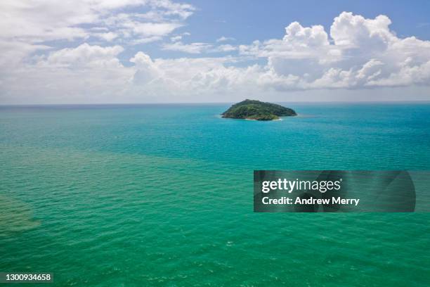 small island reef in turquoise sea, blue sky with clouds - coral sea stock-fotos und bilder