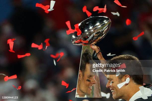 Tom Brady of the Tampa Bay Buccaneers celebrates as he is reflected in the Lombardi Trophy after defeating the Kansas City Chiefs in Super Bowl LV at...
