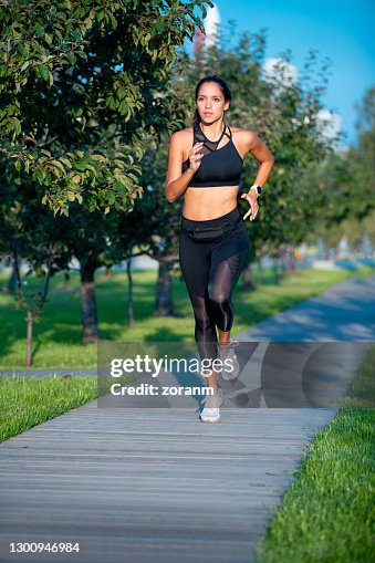 Young Woman In Sports Outfit Jogging In Public Park High-Res Stock Photo -  Getty Images