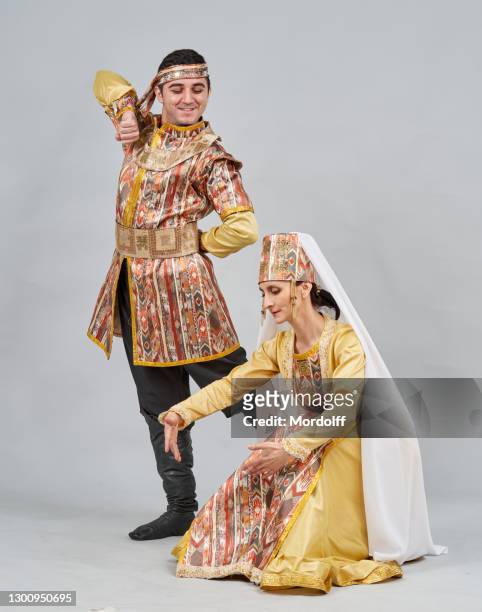 two dancers (male and female) in national costumes are showing pose of traditional armenian dance - beautiful armenian women stock pictures, royalty-free photos & images