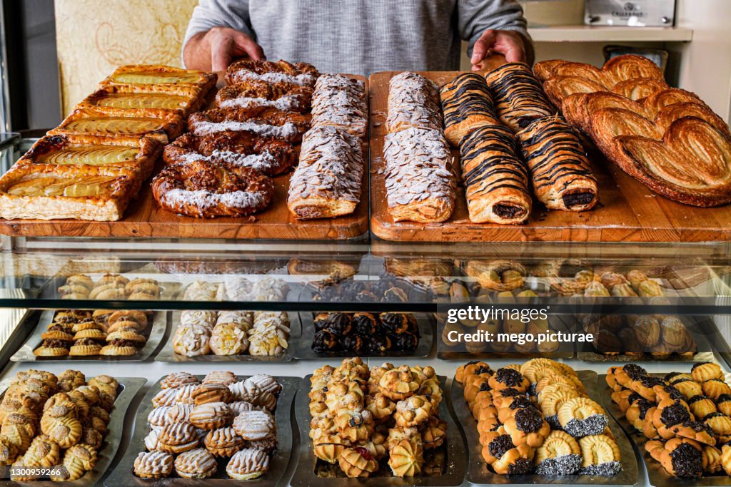 Man dispensing cakes in a pastry bakery