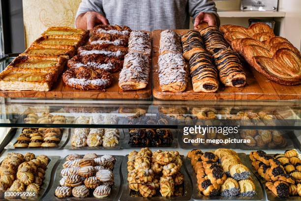 man dispensing cakes in a pastry bakery - 烤酥皮糕點類 個照片及圖片檔