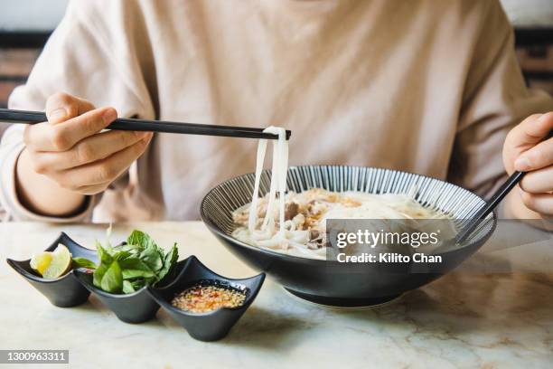 eating vietnamese beef pho for dinner - rice noodles stock pictures, royalty-free photos & images