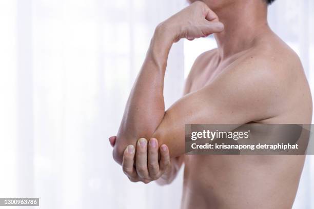 a man suffering from chronic joint rheumatism,arm joint pain,arm pain,elbow pain - mann ellbogen stock-fotos und bilder