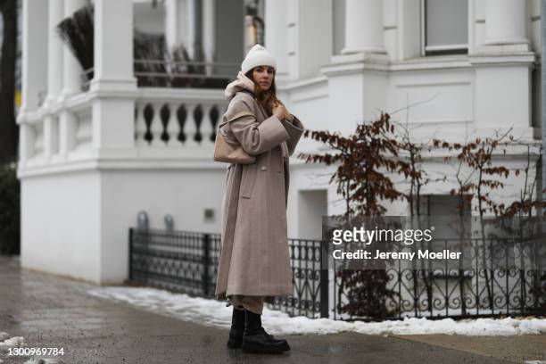 Sonja Paszkowiak wearing Ivy & oak coat, two piece from Opus, Zara boots, by Aylin König beanie and Prada beige bag on February 03, 2021 in Hamburg,...