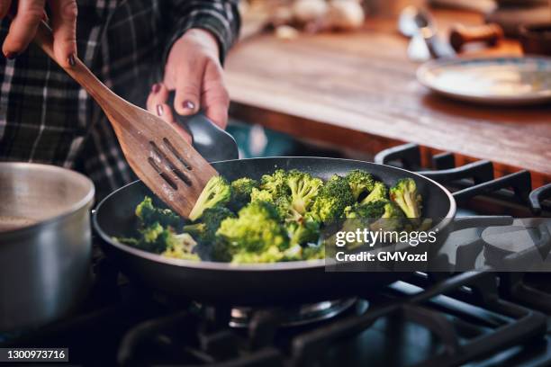 rôtir le brocoli dans une poêle pour un plat de boulgour - mode de cuisson des aliments photos et images de collection