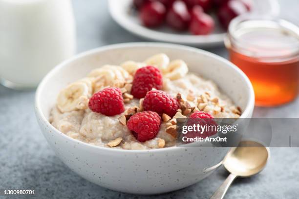 oatmeal porridge with raspberries and nuts - oatmeal stock pictures, royalty-free photos & images