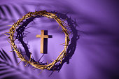 Lent season, Holy week and Good friday concept. Crown of thorns and cross on purple background