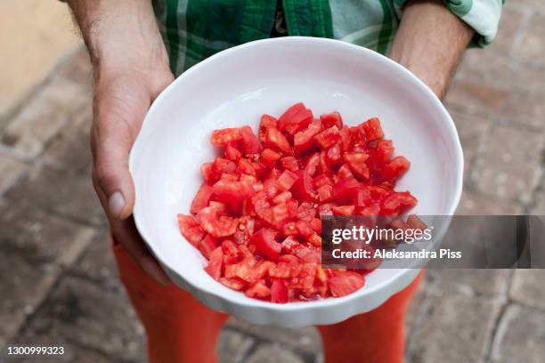 hands holding bowl of chopped tomatoes - chopped tomatoes foto e immagini stock