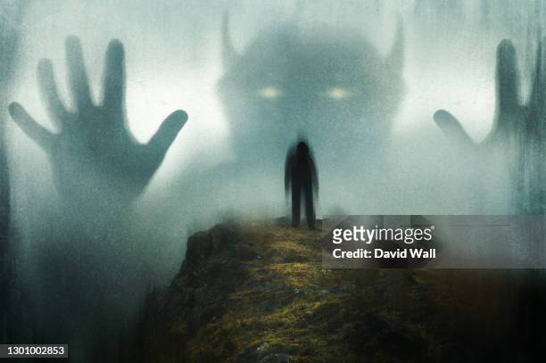 a man looking up at a huge ghostly horned demon appearing out the mist. on a moody day in the countryside. with a grunge, blurred edit. - devil stock pictures, royalty-free photos & images