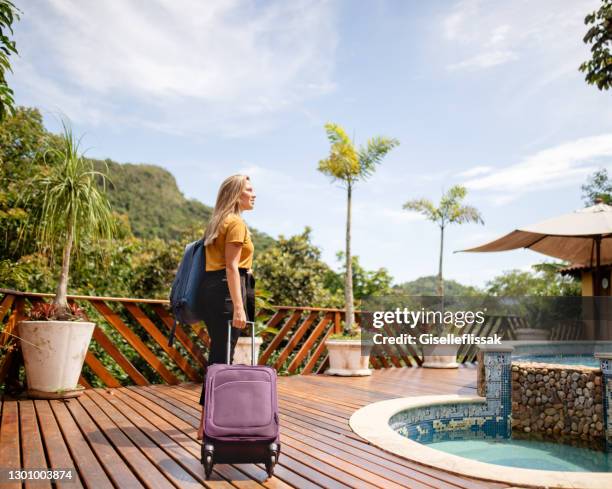 young woman arriving at a tropical resort for her vacation - summer resort imagens e fotografias de stock