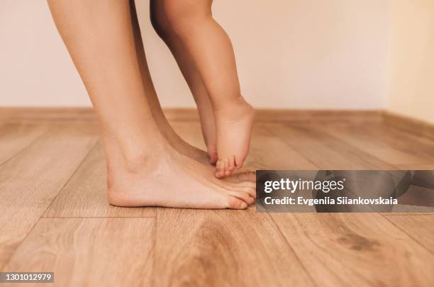 mother and baby legs close-up at home. - kids feet in home stock pictures, royalty-free photos & images