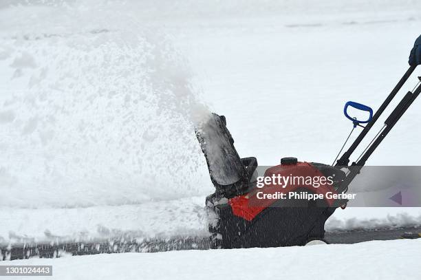man using snow blower after a snowstorm in pennsylvania - snow blower stock pictures, royalty-free photos & images
