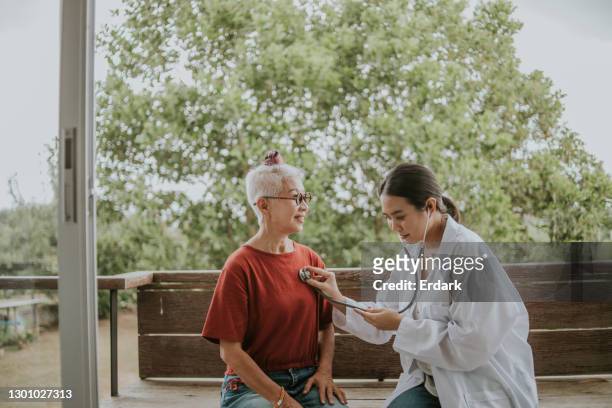 kind doctor examine senior woman’s condition- stock photo - ageing population stock pictures, royalty-free photos & images