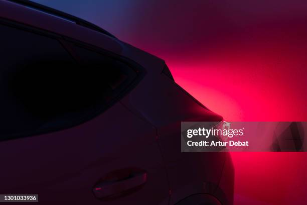 futuristic car with red tail light illuminated in the dark night. - auto rot stock-fotos und bilder