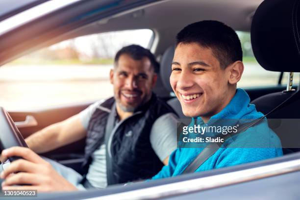 adolescente che ha una lezione di guida con istruttore maschio - guidare foto e immagini stock