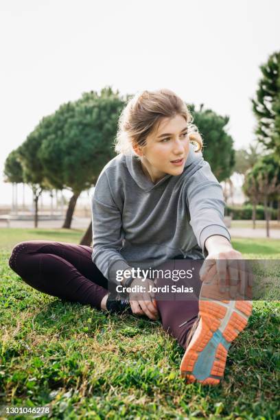 girl warming up on the grass - runner warming up stock pictures, royalty-free photos & images