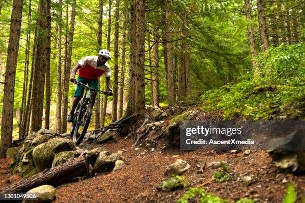 mannelijke mountainbiker die in een bos berijdt - mountainbiken fietsen stockfoto's en -beelden