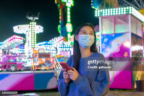 woman with facemask having fun in a funfair - covid dating stock pictures, royalty-free photos & images