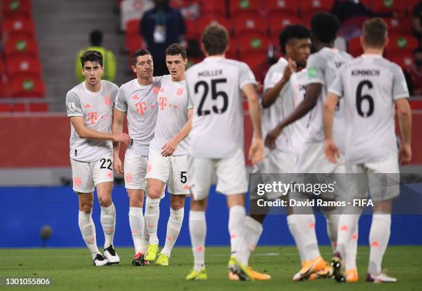 Robert Lewandowski of FC Bayern Muenchen celebrates with teammates Marc Roca and Benjamin Pavard after scoring their team's first goal during the...