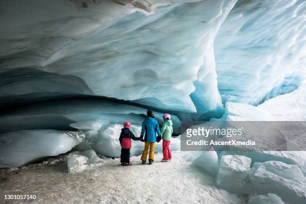 family exploring an ice cave - family snow holiday stock pictures, royalty-free photos & images