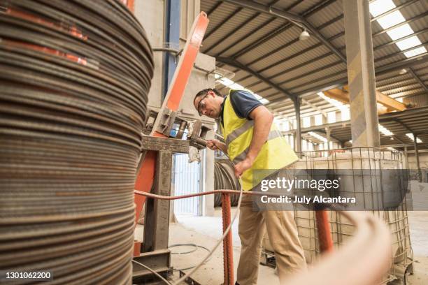 el hombre pone cable de acero en una trenza de cable en un edificio de almacén. - cable-de-acero fotografías e imágenes de stock