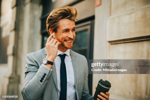 businessman using  bluetooth earphones - bluetooth headphones stock pictures, royalty-free photos & images