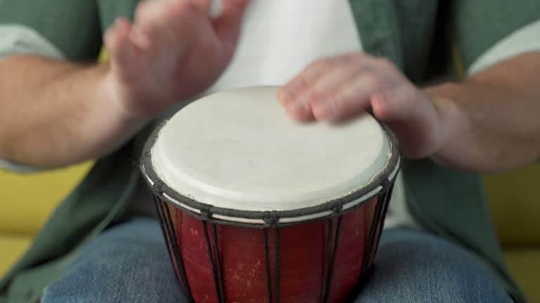 Male hands tapping djembe, bongo in rhythm. Musical handmade ...