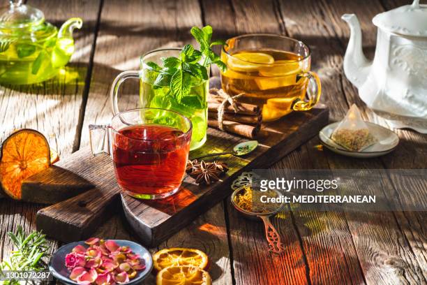 infusão de chá e ervas com ervas secas na mesa rústica de madeira - infused - fotografias e filmes do acervo
