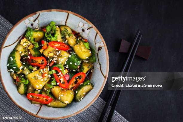 close up of chinese broken cucumbers salad with sesame, chili pepper and ginger - sesam stock-fotos und bilder