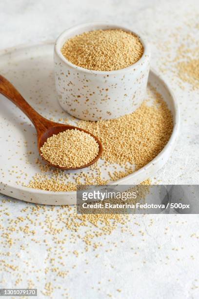 bowl of raw amaranth grain with a spoon - amarant stock-fotos und bilder