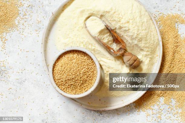 plate of raw amaranth flour with a scoop and amaranth seeds - amarant stock pictures, royalty-free photos & images