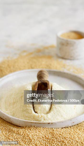 plate of raw amaranth flour with a scoop and amaranth seeds - amarant stock pictures, royalty-free photos & images