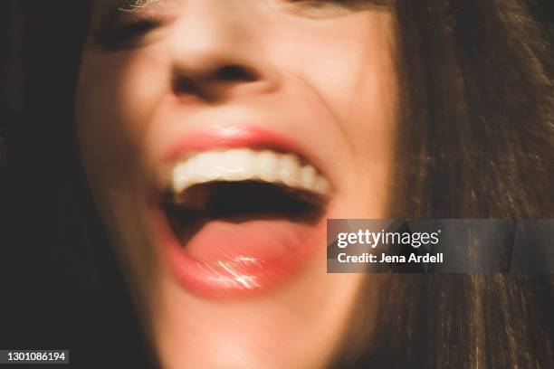 closeup woman laughing mouth, shouting mouth - blurred motion photos et images de collection