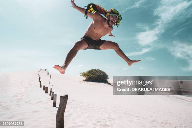 an active young man on a journey in the desert - hunky guy on beach stock pictures, royalty-free photos & images