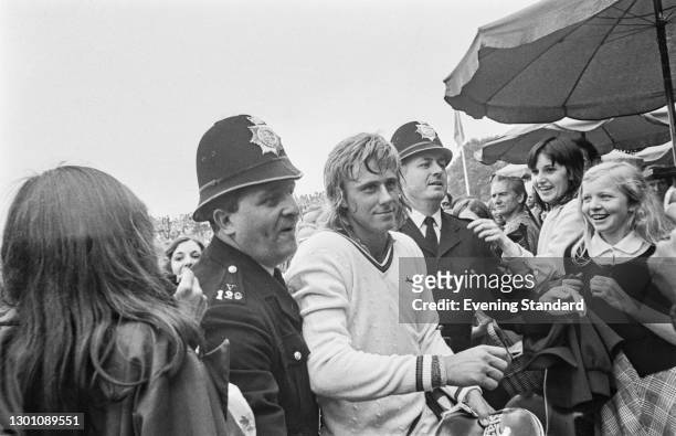 Two police officers escort Swedish tennis player Björn Borg past his fans during the Wimbledon Championships in London, UK, 29th June 1973.
