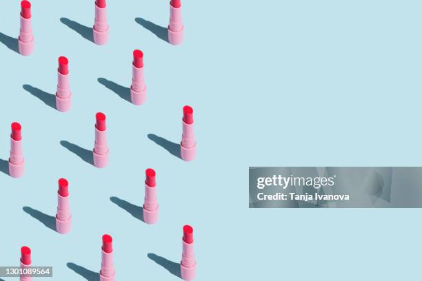 pattern made of pink lipstick with sun shadows on pastel blue background. flat lay, top view. beauty and cosmetics background. - art product photos et images de collection
