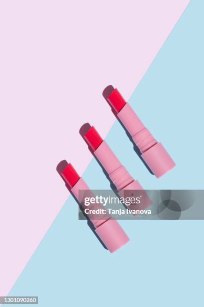 pink lipstick with sun shadows on pastel blue and pink background. flat lay, top view, copy space. beauty and cosmetics background. - makeup products stock pictures, royalty-free photos & images