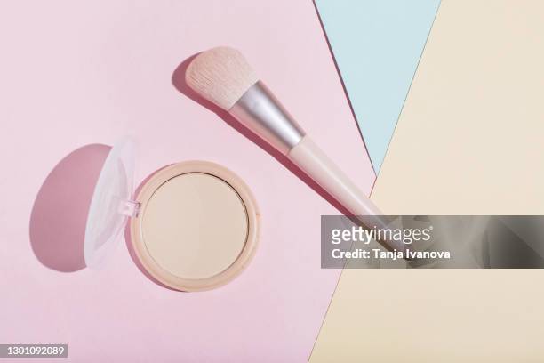makeup powder and brush with the shadow on pastel pink, beige and blue background. flat lay, top view, copy space - compact foto e immagini stock