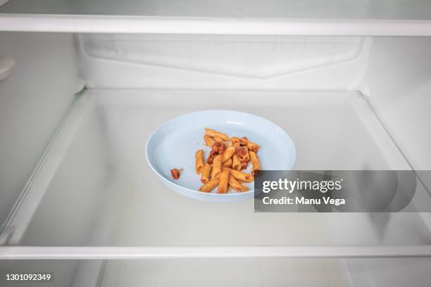 plate of macaroni empty refrigerator - leftovers stockfoto's en -beelden