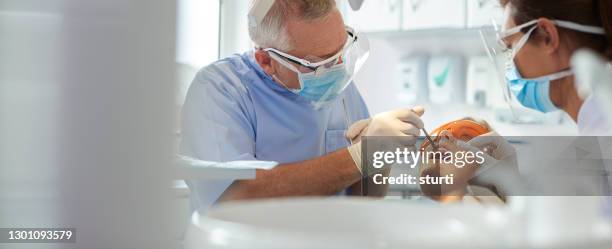 dentist team wearing covid ppe - dentist stock pictures, royalty-free photos & images