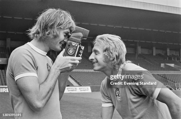 English footballer Rodney Marsh of Manchester City FC films team-mate Denis Law at the start of the 1973-74 football season, UK, 30th August 1973.