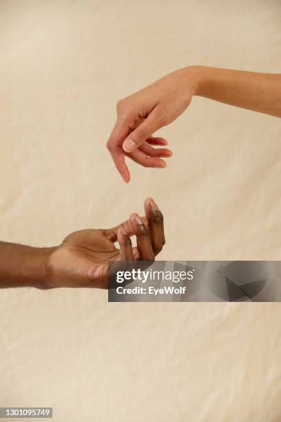 a man and woman joining hands together against a natural background - handshake abstract stock pictures, royalty-free photos & images